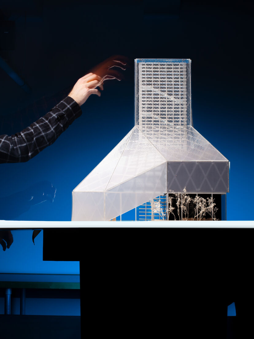 A 30”-tall architectural model of a library and datacenter, photographed in front of a dark blue background.